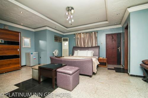 a bedroom with a bed and a table in it at Platinum Inn Gee Hotel in Suru Lere