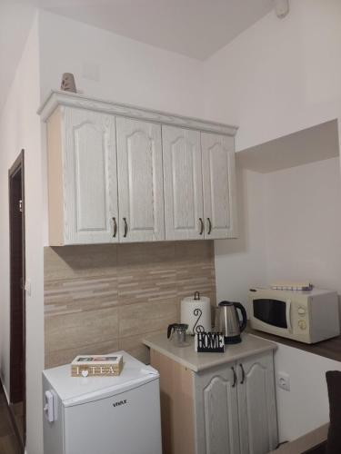 a kitchen with white cabinets and a microwave at Aleksa in Cetinje
