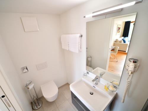 a white bathroom with a sink and a mirror at Boato Bistrot & Bed in Tegna