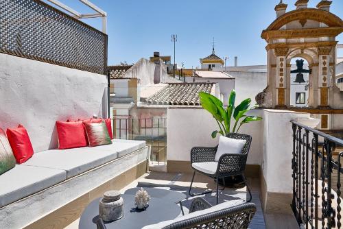 a balcony with a couch and a chair on a roof at Vincci Molviedro Suites Apartments in Seville