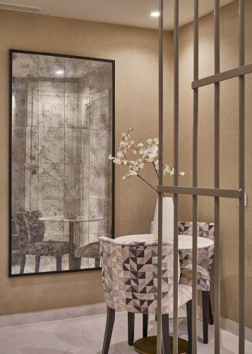 a table and a chair with a vase of flowers at Vincci Molviedro Suites Apartments in Seville