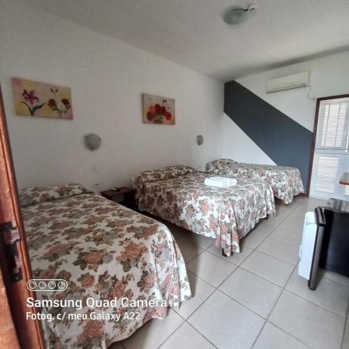 a hotel room with two beds and a tv at Hotel Sol A Sol in Cananéia