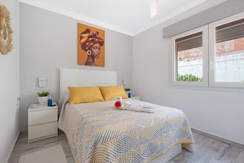 a bedroom with a bed and a painting on the wall at Apartamento junto al Mar in Araya