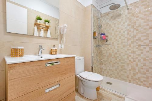 een badkamer met een toilet, een wastafel en een douche bij Apartamento junto al Mar in Araya