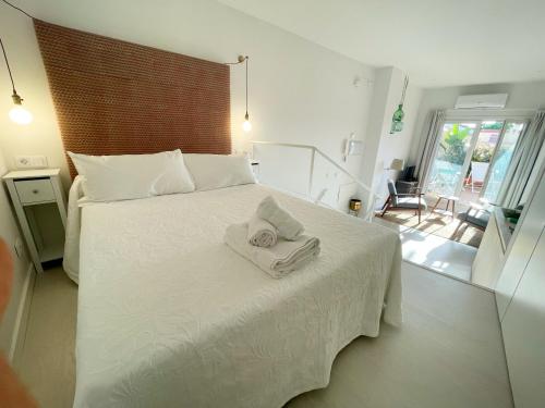 sypialnia z białym łóżkiem i ręcznikami w obiekcie Eva Recommends San Gil w Sewilli