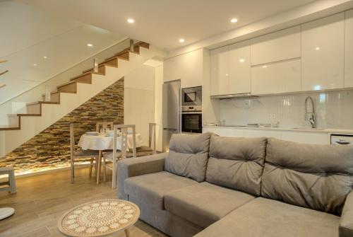a living room with a couch and a dining room at Flor de Valença Guest House in Valença