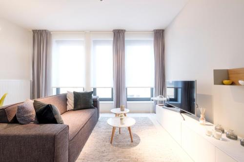 ein Wohnzimmer mit einem Sofa und einem TV in der Unterkunft Brussels city flats in Brüssel