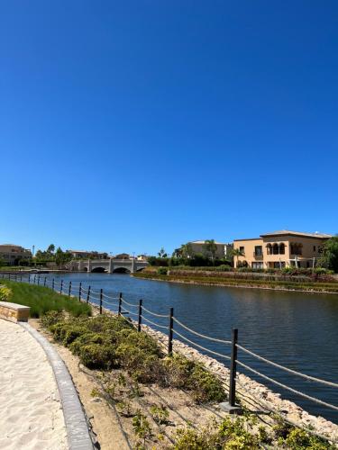a path next to a river with a bridge at Elegant 1BR Chalet at Marassi Marina 2 in El Alamein