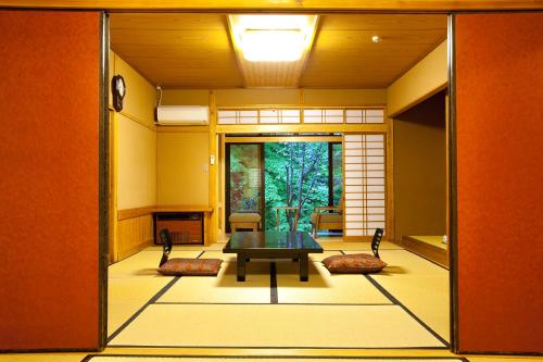 a room with a table in the middle of a room at Kurokawa Onsen Oku no Yu in Minamioguni