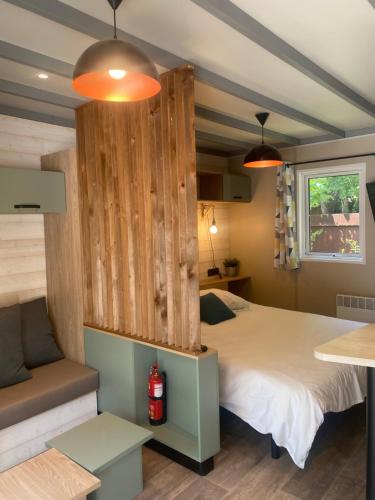 1 dormitorio con 1 cama con pared de madera en Camping Frédéric Mistral, en Castellane