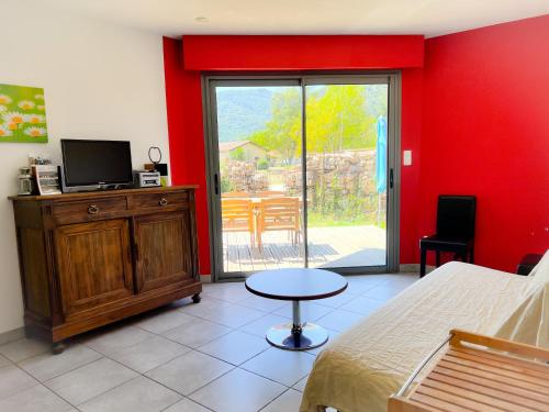 1 dormitorio con 1 cama, TV y mesa en Le Domaine d'Arignac, en Arignac