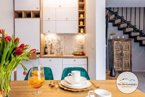 a kitchen and dining room with a wooden table at Apartamenty Na Osi Gondoli - wyciągi narciarskie, trasy rowerowe tylko 70 metrów in Szczyrk