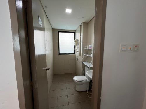 Elle comprend une petite salle de bains pourvue de toilettes et d'une fenêtre. dans l'établissement D'Gunduls Homestay Family Suite 2R 2B by DGH I-CITY, à Shah Alam