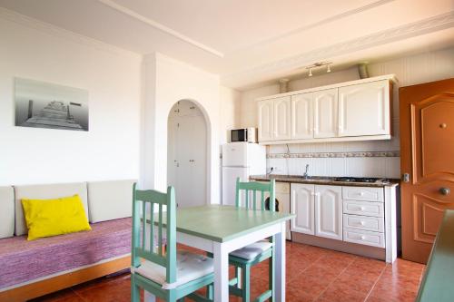 a kitchen with a table and chairs in a room at Apartamentos Turisticos Trajano in Bolonia