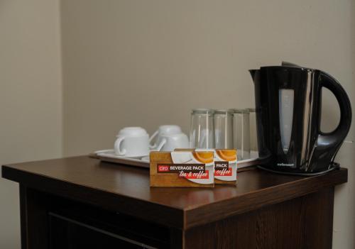 stolik z dwoma słoikami miodu i ekspres do kawy w obiekcie Bayside Hotel Pietermaritzburg w mieście Pietermaritzburg