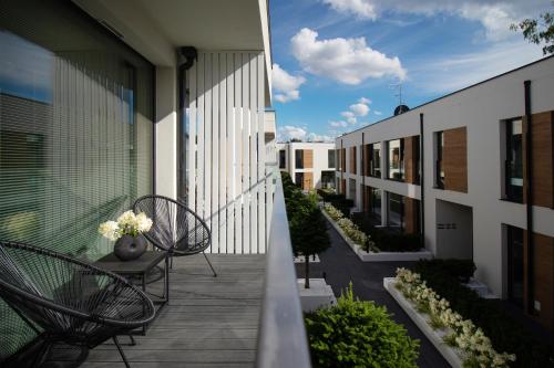 a balcony with chairs and plants on a building at Apartamenty Olimpijska by RENT4YOU in Olsztyn