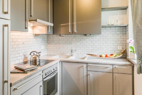 a kitchen with white cabinets and a sink at Residence Pfeifhofer in Campo Tures