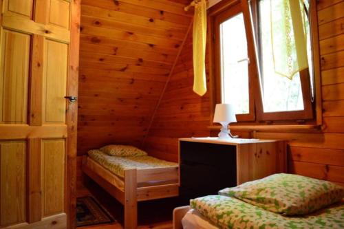 sypialnia z 2 łóżkami w drewnianym domku w obiekcie Domki letniskowe BAŁTYK w Łebie