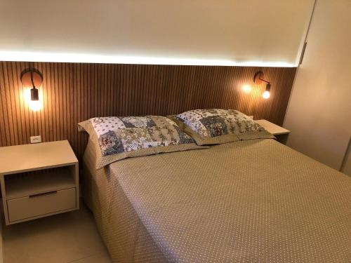 Un dormitorio con una cama con dos luces. en Ed. Vila Malorca, en Bombinhas