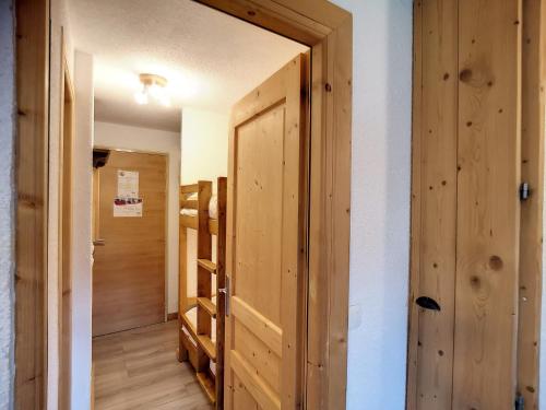 Cette chambre dispose d'une porte en bois et d'un couloir. dans l'établissement Studio rénové 4 pers, ski aux pieds, Les Menuires - 21m², 2 Flocons Or, Accès direct pistes. - FR-1-178-364, aux Menuires