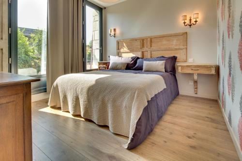 a bedroom with a large bed with a wooden headboard at Château de Candes - Art & Spa in Candes-Saint-Martin