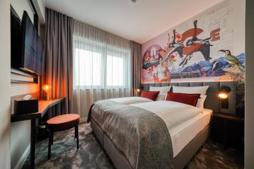 ein Schlafzimmer mit einem großen Bett und einem großen Wandgemälde in der Unterkunft NYCE Hotel Hannover in Hannover