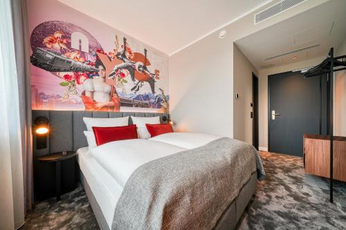 a bedroom with a large bed and a painting on the wall at Vienna House Easy by Wyndham Hannover in Hannover