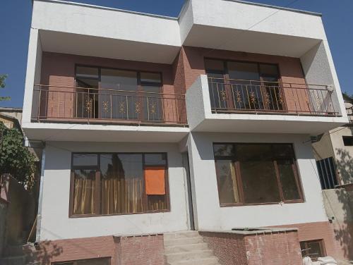 a building with a balcony on top of it at Mary's Cozy & Lovely studio on very quiet Khosharauli street in Tbilisi City