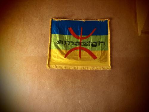 a flag is hanging on a wall at Casbah d'hôte La Jeanne Tourisme Ecologique in Boumalne