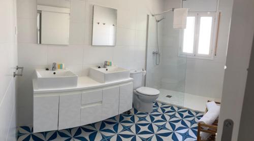 a white bathroom with two sinks and a toilet at Zona5 Apartamentos Turísticos in El Vendrell