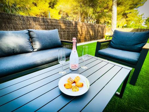 einen Tisch mit einer Flasche Wein und einem Teller Essen in der Unterkunft Villa PAM Beach house Playa de Muro - 200m to beach in Alcúdia