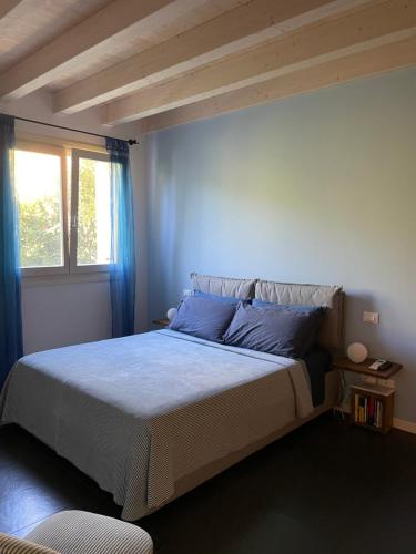 una camera da letto con un letto con cuscini blu e una finestra di Villa Arzilla a Desenzano del Garda