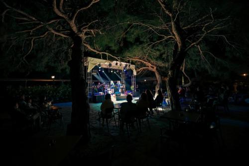a group of people sitting at tables in front of a stage at Crystal Prestige Elite in Kemer