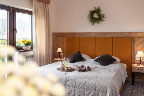 a bedroom with a large bed with a wooden headboard at Pensjonat Litworówka Wellness&SPA in Poronin