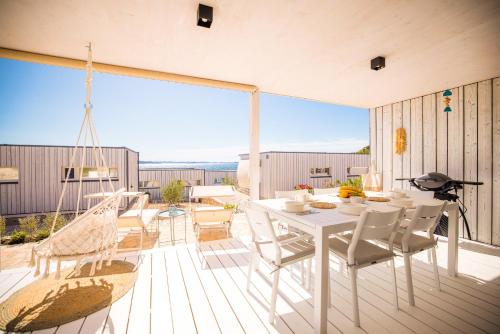 a white dining table and chairs on a deck at BUQEZ ECO RESORT - Beach Villa 12 - Nice view in Drage
