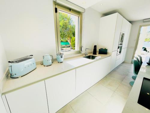 a kitchen with white cabinets and a window at Chalet PAM - 1 line s'Albufera lake - near by beach in Alcudia