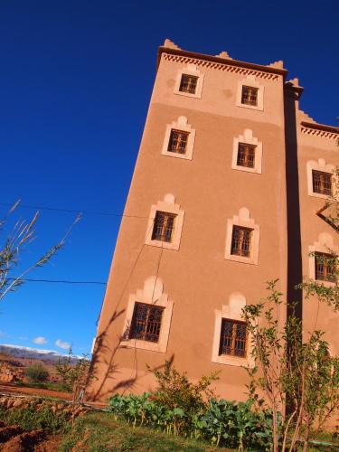 a tall building with windows on the side of it at Casbah d'hôte La Jeanne Tourisme Ecologique in Boumalne