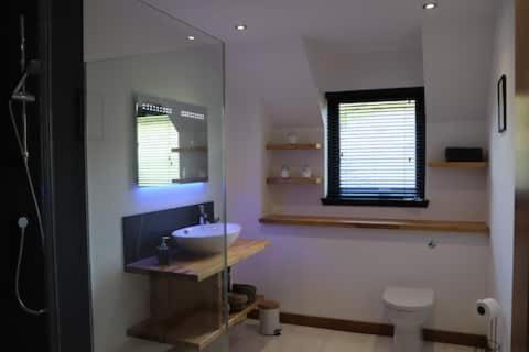 baño con lavabo y aseo y ventana en The Cottage - spacious getaway with stunning views, en Auchenblae