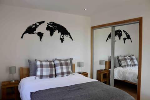 a bedroom with a bed and a large mirror at The Cottage - spacious getaway with stunning views in Auchenblae