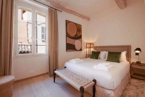 een slaapkamer met een wit bed en een raam bij Pick A Flat's Apartments in Saint-Tropez- Rue Victor Laugier in Saint-Tropez