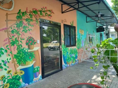 ein Gebäude mit einem Gemälde von Pflanzen darauf in der Unterkunft Nhat Ha Homestay in Vũng Tàu