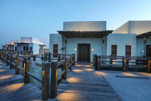 a building with a wooden fence in front of it at The Chedi Katara Hotel & Resort in Doha