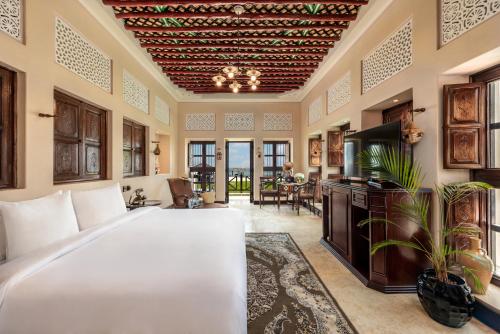 a bedroom with a large bed and a living room at Al Maya Island & Resort in Abu Dhabi