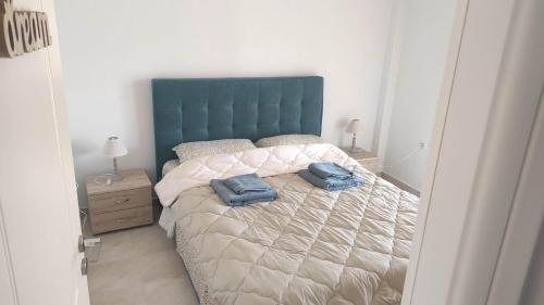 een slaapkamer met een bed met twee blauwe handdoeken erop bij Evelina's suite in Artemida