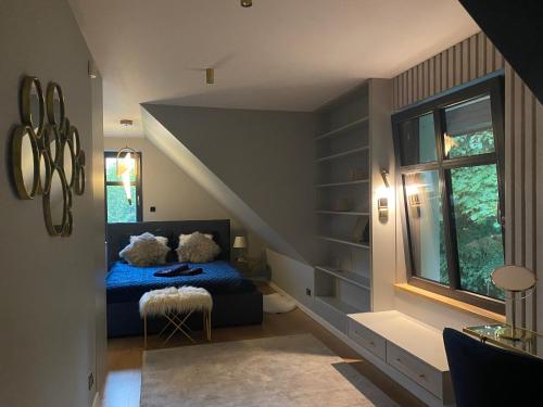 Un dormitorio con una cama azul y una ventana en MazuryDreamHouse, en Pelnik