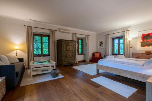 a large bedroom with a large bed and a couch at Gästehaus Golf Club Gut Murstätten in Lebring