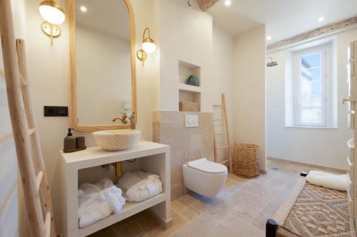 een badkamer met een wastafel, een toilet en een spiegel bij Pick A Flat's Apartments in Saint-Tropez- Rue Victor Laugier in Saint-Tropez