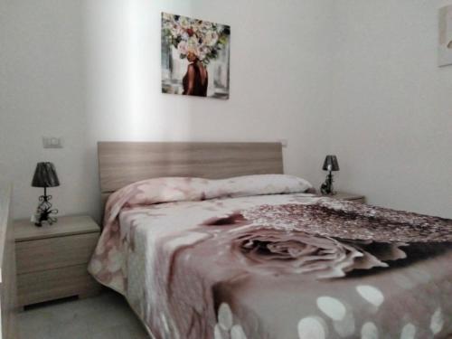 1 dormitorio con 1 cama, 2 lámparas y 1 foto en CASA RED ROSE, en Maddaloni