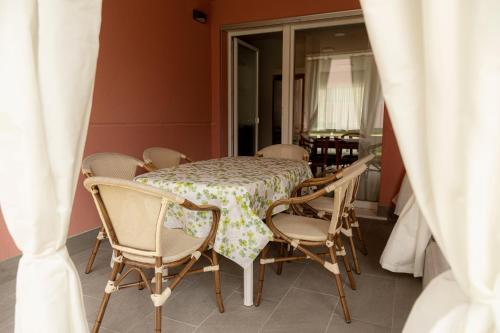 a table and chairs in a room with a window at HOLIDAY APARTMENTS GIULIA - Blue in Pietramurata