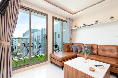 a living room with a couch and a table at Rare XXXL Swimming Pools Resort - 500Mbps Blazing Fast Free WIFI - Top Floor Pool View Balcony - Gym - Sauna - Kids Playground - Supermarkets in Pattaya South